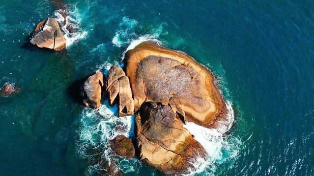 Aerial view of the bare rocky island in the middle of a sea
