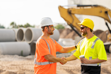 Two construction workers with hardhat helmet on construction site. Construction engineer workers in...