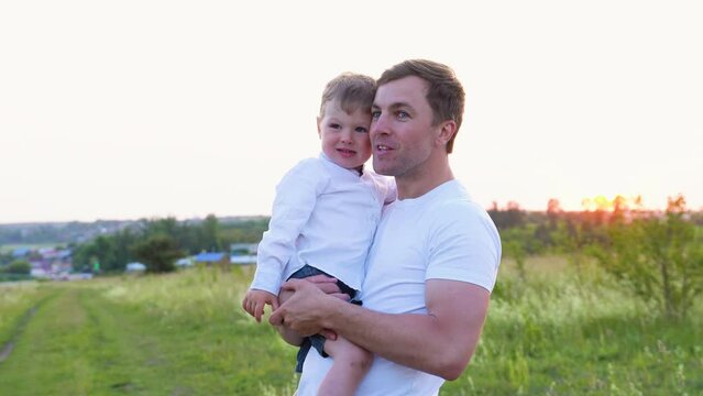 Happy dad hugging his little son in the park