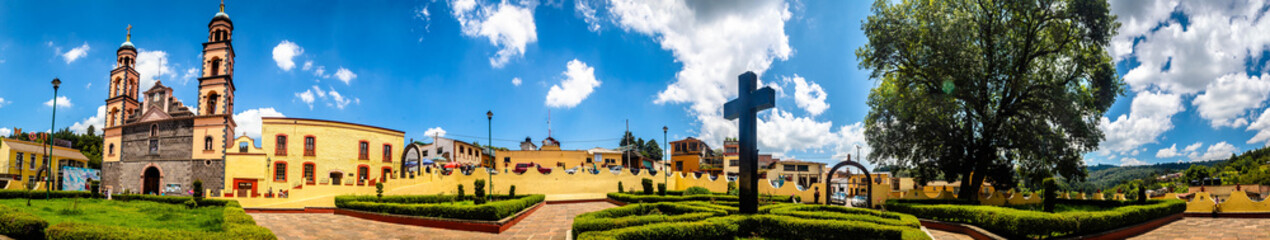 panoramic view of yellow church and catholic cross in a garden in el oro de hidalgo, state of mexico 