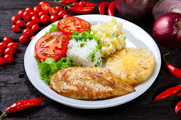 Grilled chicken breast fillet, rice, salad, potatoes, pineapple slice
