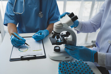 Scientist working with a microscope Laboratory team doing medical research Scientific test tubes in the laboratory for analyzing data in the lab Biological concept, insurance.