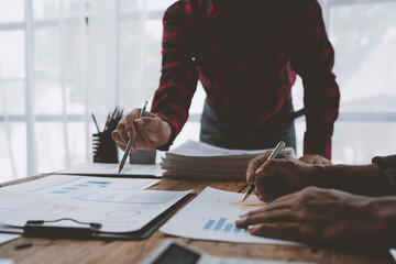 Obraz premium Team work process Team of business people searching for piles of papers and having a meeting Discuss business statistics, profits, financial growth rates in graph papers. financial data chart.