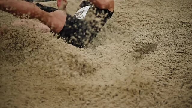 Close-up of a long jump. Jumping into the sand, slow motion. Athletics competitions