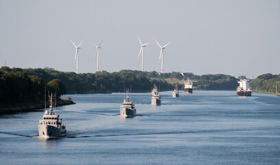 Convoy of the military navy ships with a set of wind generators in the background. Military...