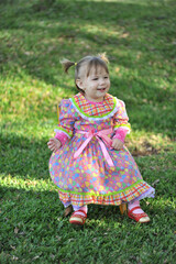crian&ccedil;a sorridente com vestido colorido de festa junina, festa caipira  de s&atilde;o jo&atilde;o 