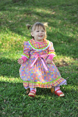 criança sorridente com vestido colorido de festa junina, festa caipira  de são joão 