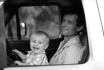 avô com neto sorridente andando de carro felizes