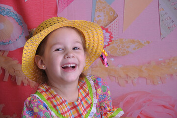 menina sorridente com vestido de festa junina, festa caipira brasileira de são joão 