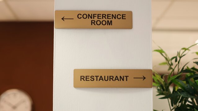Close up of hotel facilities plaques on hotel lounge wall and folders of tourist accommodation paperwork in reception. Directions to conference room, spa center and restaurant resort amenities