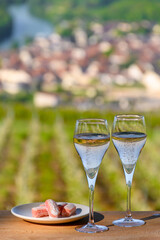 Tasting of premier cru sparkling rose wine with bubbles champagne with view on green pinot noir, meunier vineyards of Hautvillers, France.