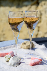 Tasting of grand cru sparkling rose wine with bubbles champagne with view on old houses of Oger, small village with grand cru vineyards, France.