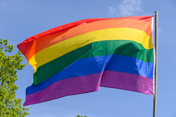 Gay pride rainbow colours flag and blue sky