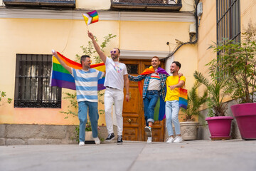 Homosexual male friends leaving home to gay pride party, diversity of young people in the city, road to the demonstration with the rainbow flags, lgbt concept