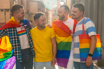 Gay pride party in the city, portrait of couples of men having fun at the demonstration with the rainbow flags, lgbt concept