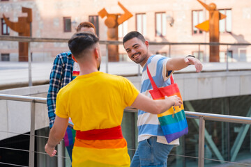 Man waving and hugging at the demonstration with the rainbow flags, gay pride party in the city, lgbt concept