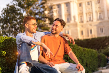 Portrait of gay newlyweds sitting in the park at sunset in a park in the city. Diversity and lgbt concept