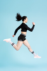 Side portrait of athletic woman in black sportswear running marathon, jogging, speed race