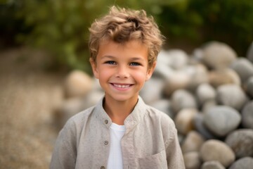 Portrait of a cute little boy with curly hair smiling at the camera