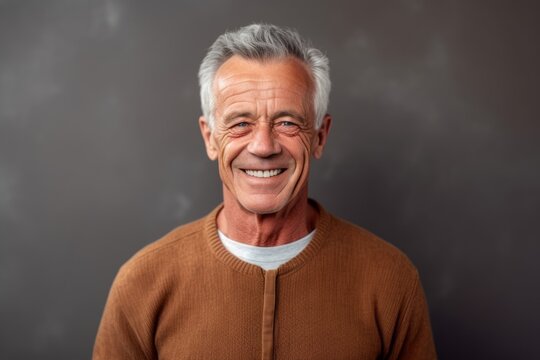 Medium shot portrait photography of a grinning man in his 60s that is wearing a chic cardigan against a paper or textured background .  Generative AI