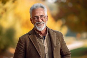Portrait of a senior man smiling in a park in autumn.