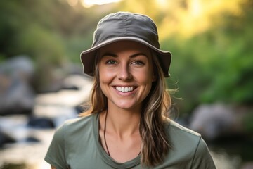 Close-up portrait photography of a satisfied woman in her 30s that is wearing a cool cap or hat against a scenic hiking trail with a waterfall in the distance background .  Generative AI