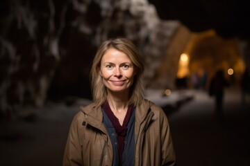 Medium shot portrait photography of a pleased woman in her 40s that is wearing a chic cardigan against an underground cave or cavern background .  Generative AI