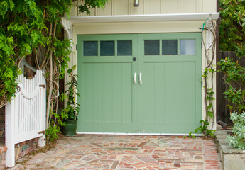 vintage bungalow with a trellis over the one car garage