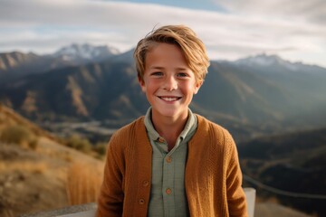 Fototapeta na wymiar Portrait of a smiling boy standing on a terrace in the mountains
