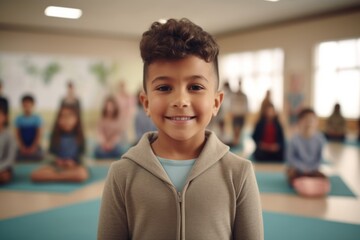 Portrait Of Little Boy Smiling To Camera In Gym With Teacher