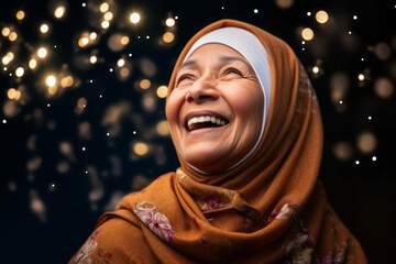 smiling senior muslim woman wearing hijab over christmas lights background