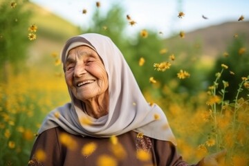 Medium shot portrait photography of a pleased woman in her 90s that is wearing hijab against a picturesque sunflower field with bees and butterflies background .  Generative AI - obrazy, fototapety, plakaty