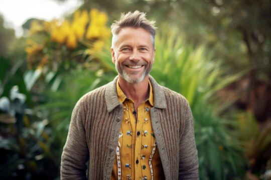 Medium shot portrait photography of a grinning man in his 40s that is wearing a chic cardigan against a garden or botanical background .  Generative AI