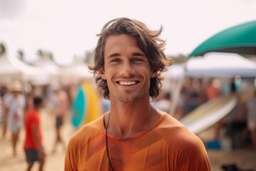 Portrait of a smiling young man with surfboard on the beach