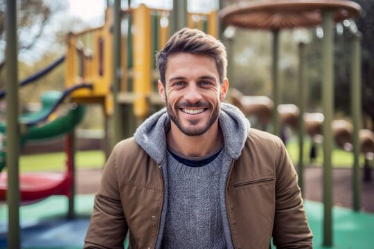 Medium shot portrait photography of a pleased man in his 20s that is wearing a chic cardigan against an active playground with children playing background .  Generative AI