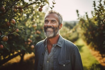 Medium shot portrait photography of a grinning man in his 40s that is wearing a trendy jumpsuit against a sunlit apple orchard with ripe apples on trees background .  Generative AI