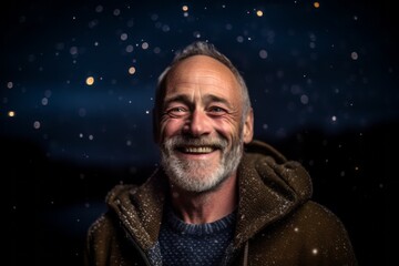 Portrait of a happy senior man at night in the snow.
