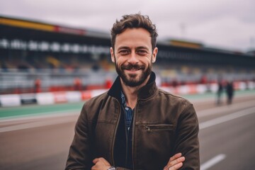 Medium shot portrait photography of a pleased man in his 40s that is wearing a chic cardigan against an exciting go-kart racing track with drivers competing background .  Generative AI