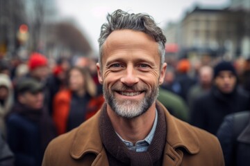 Fototapeta premium Portrait of a middle-aged man with gray hair and beard on the street.
