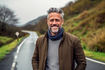 Portrait of a handsome middle-aged man standing on a road in the countryside