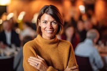 Medium shot portrait photography of a satisfied woman in her 40s that is wearing a cozy sweater against a charity gala event with auction and celebrities background .  Generative AI