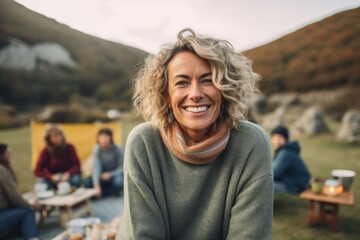 Medium shot portrait photography of a satisfied woman in her 40s that is wearing a cozy sweater against a scenic countryside picnic with friends and family background .  Generative AI