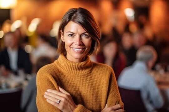 Medium shot portrait photography of a satisfied woman in her 40s that is wearing a cozy sweater against a charity gala event with auction and celebrities background .  Generative AI