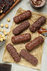Tasty chocolate bars with caramel and nuts on light table, flat lay