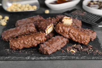 Tasty chocolate bars with caramel on light grey table, closeup