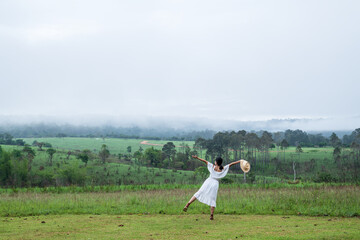 Free woman breathing clean air in nature forest. Enjoying the nature. Happy girl from the back with open arms in happiness. Fresh outdoor woods, wellness healthy lifestyle concept.