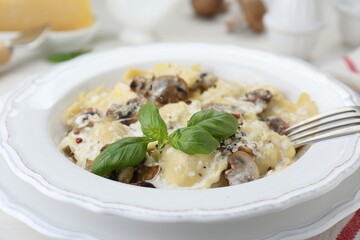 Delicious ravioli with mushrooms and cheese served on table, closeup