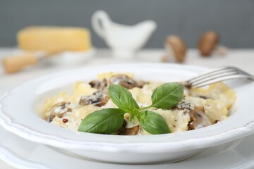 Delicious ravioli with mushrooms and cheese served on table, closeup