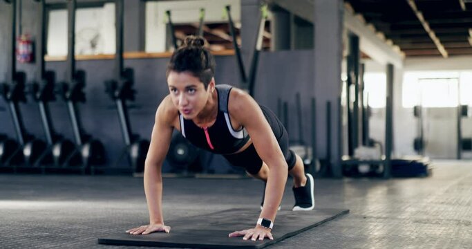 Sports, gym and female athlete doing a pushup workout for health, wellness and strength training. Fitness, challenge and strong woman doing an arm exercise routine with motivation at a sport center.