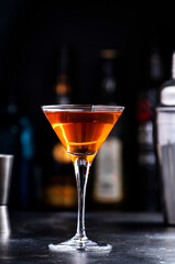Bobby Burns alcoholic cocktail drink with scotch whiskey, vermouth and liquor in martini glass, dark bar counter background